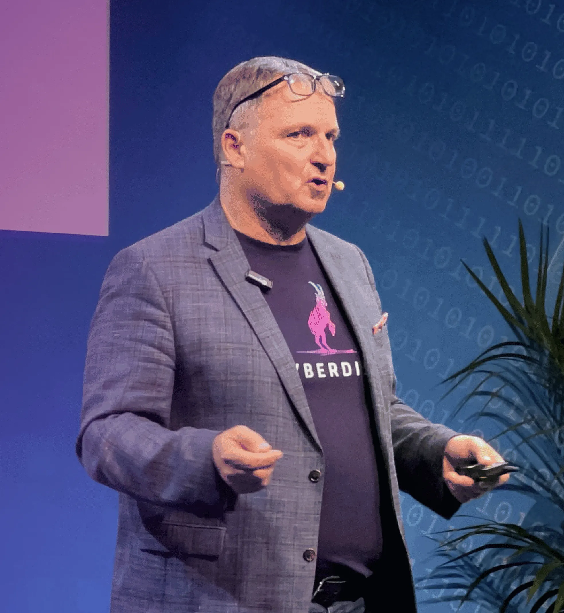 Referent im Cyberdise-T-Shirt bei einem Vortrag auf einer Messebühne