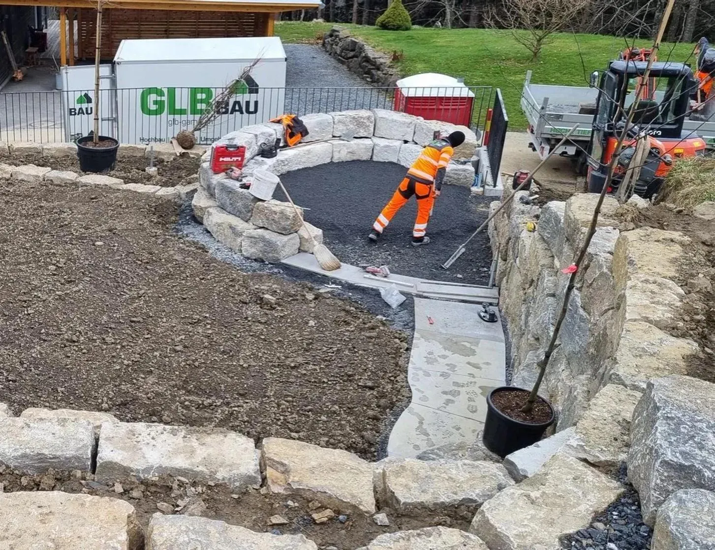 GLB workers laying a stone garden wall on a building site
